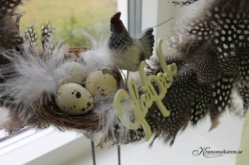 Krans med fjädrar. ca 30 cm.