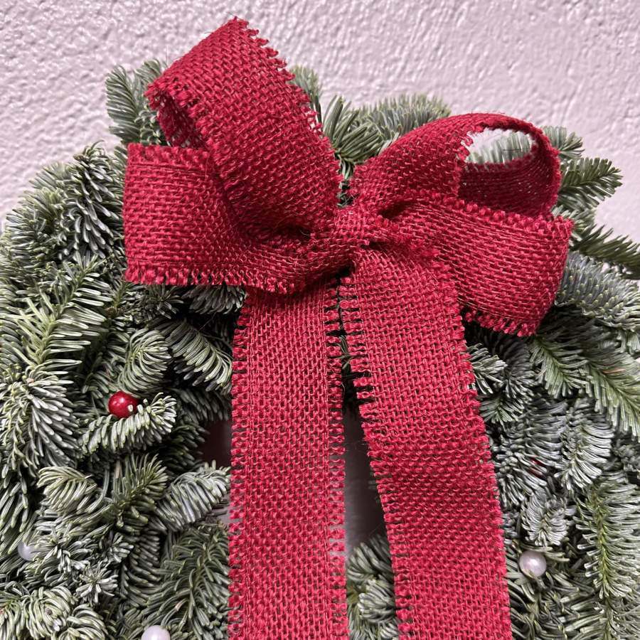 Julkrans med rosett av röd juteväv och pärlnålar. Diameter ca 30cm