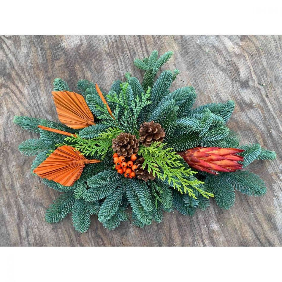 Gravdekoration liggande med bär, palmblad och kottar. ca 60x40 cm