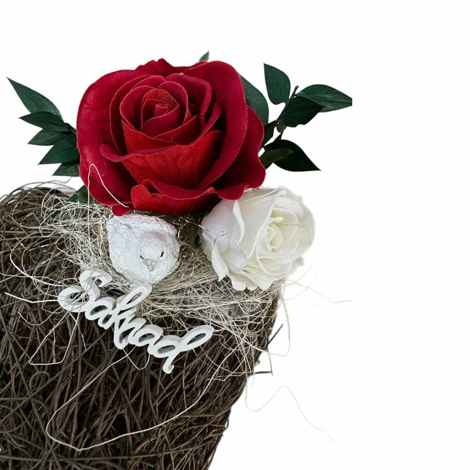 Gravdekoration med två rosor i vitt och rött, duva och skylt