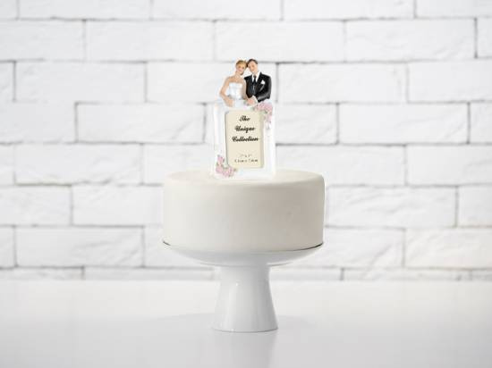 Vackert brudpar med fotoram för tårtdekoration till bröllopet