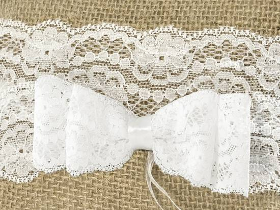 Ringkudde med vit dubbelrosett och vitt spetsband